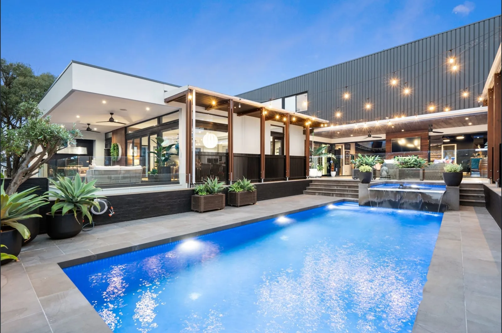 New build home with pool, outdoor and festoon lighting at dusk - Yarrambat, VIC